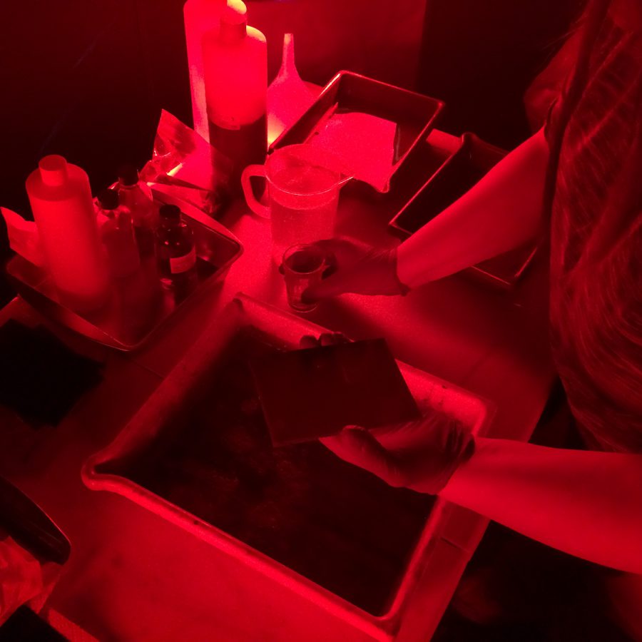 This is a typical setup inside the portable darkroom. Here one of my students is about to pour developer on the tintype to bring out the image.