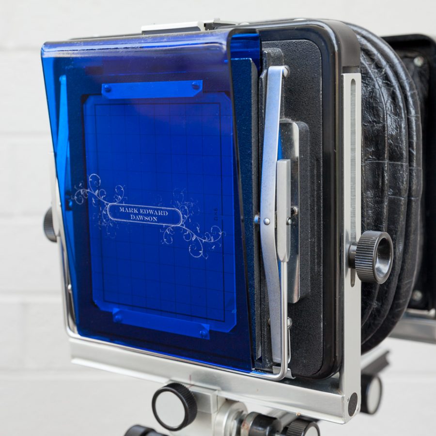 Groundglass cover with my name and a design etched into blue acrylic, shown here on my Arca-Swiss 4x5 camera.