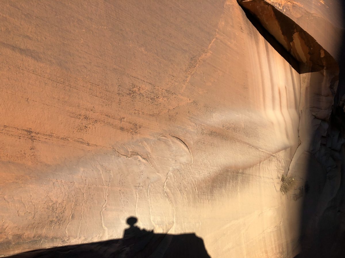 Mark's shadow waits for his hiking companions along the wall of Fifty Mile Canyon in Utah.